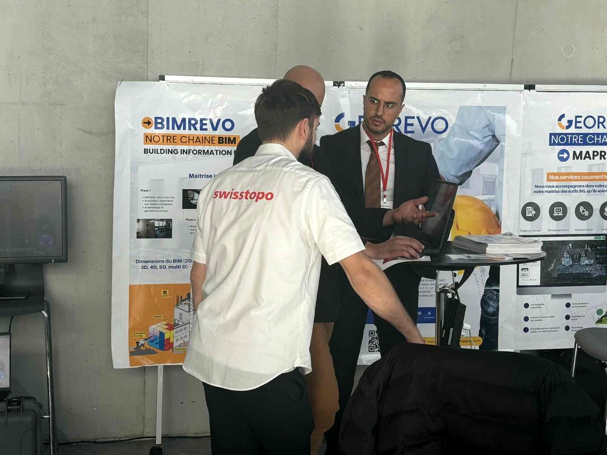 L'équipe GEOREVO sur son stand, devant les panneaux BIMREVO et MAPREVO