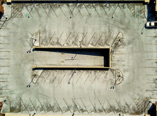 an aerial view of a parking lot with several empty benches