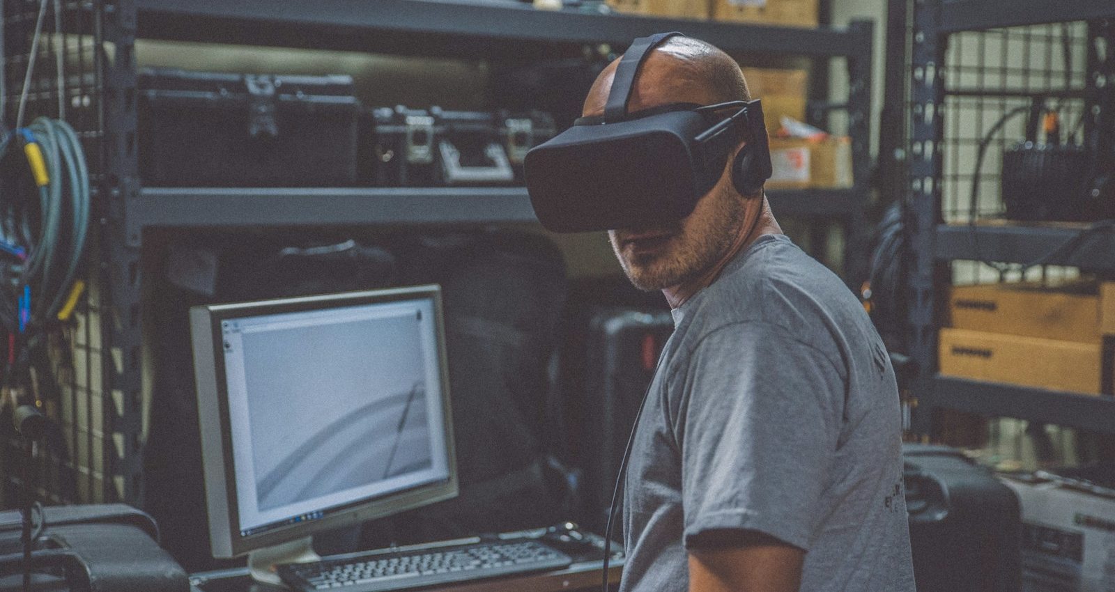 person using black VR Headset in front of computer