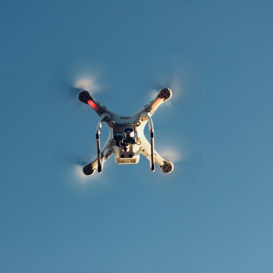 low angle photography of RC quadcopter at mid air